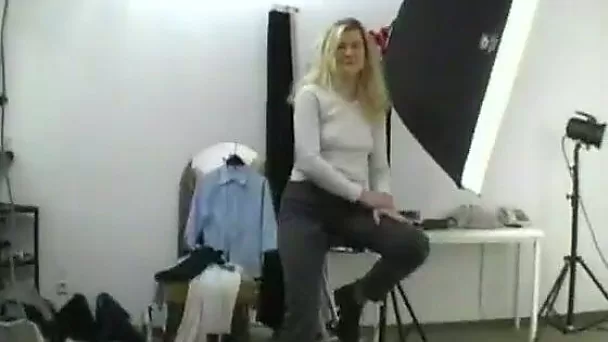 Cute blonde getting naked in the professional photo studio