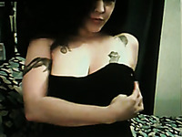Dark haired tattooed slut strips and shows her boobs