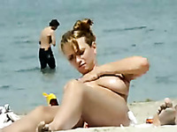 Spy video of sexy blonde hottie rubbing her boobs with sun protect lotion on a beach