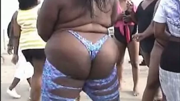 Lewd ebony chick flashes her ass and cunt on a beach