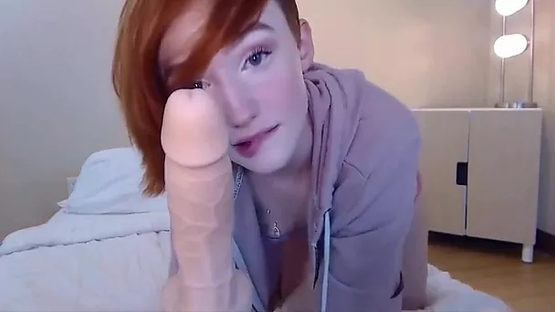 Redhead babe having fun with dildo and sucking it off