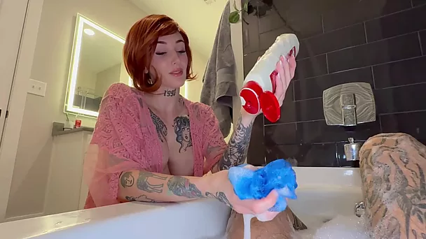 Tätowierte rothaarige Stiefmutter mit großen Brüsten gibt einen schlampigen Handjob im Schaumbad